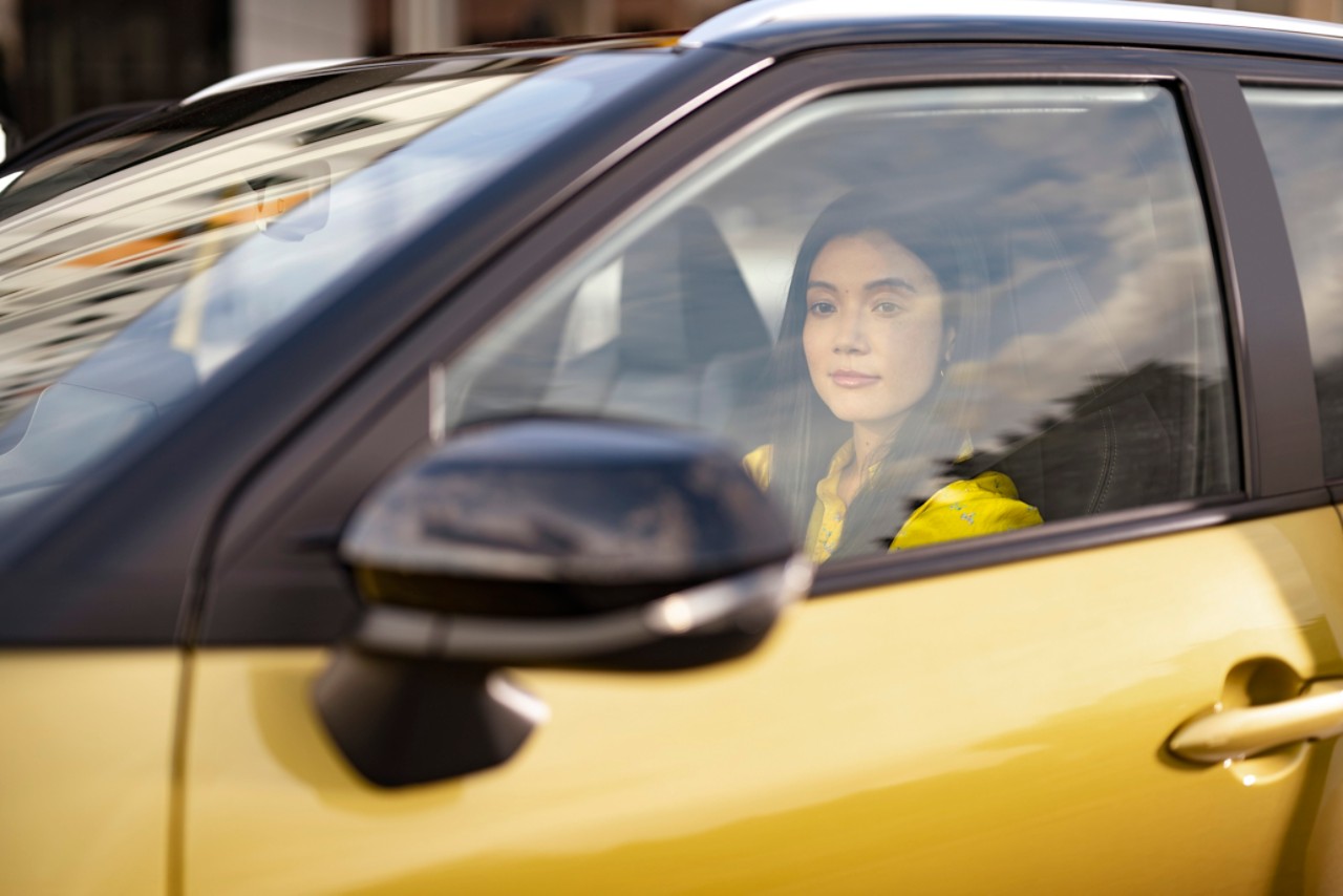 Autofahrerin schaut in den Rückspiegel